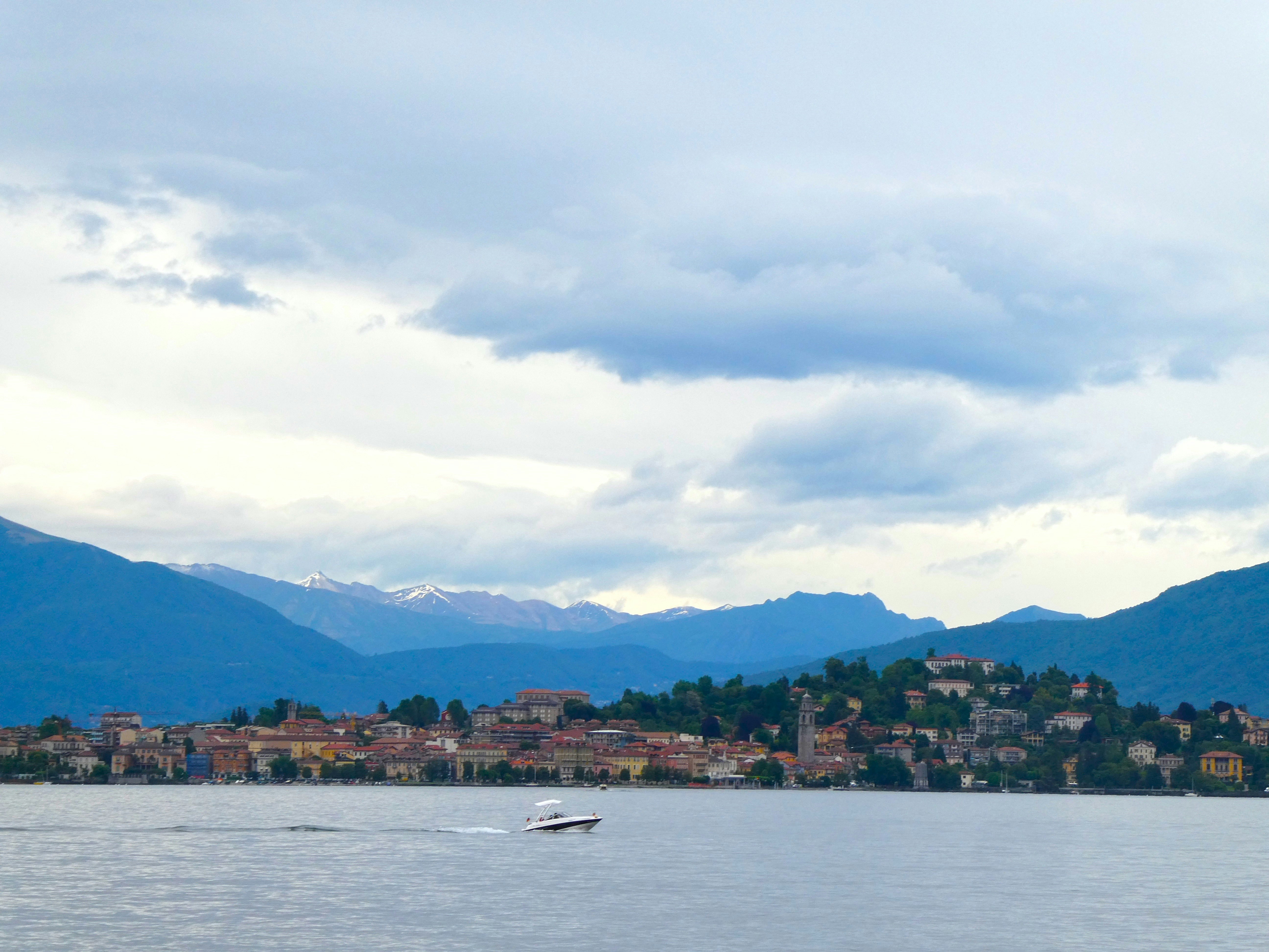 Boat on lake, clouds over hazy hills on Lago Maggiore, Baveno, Italy