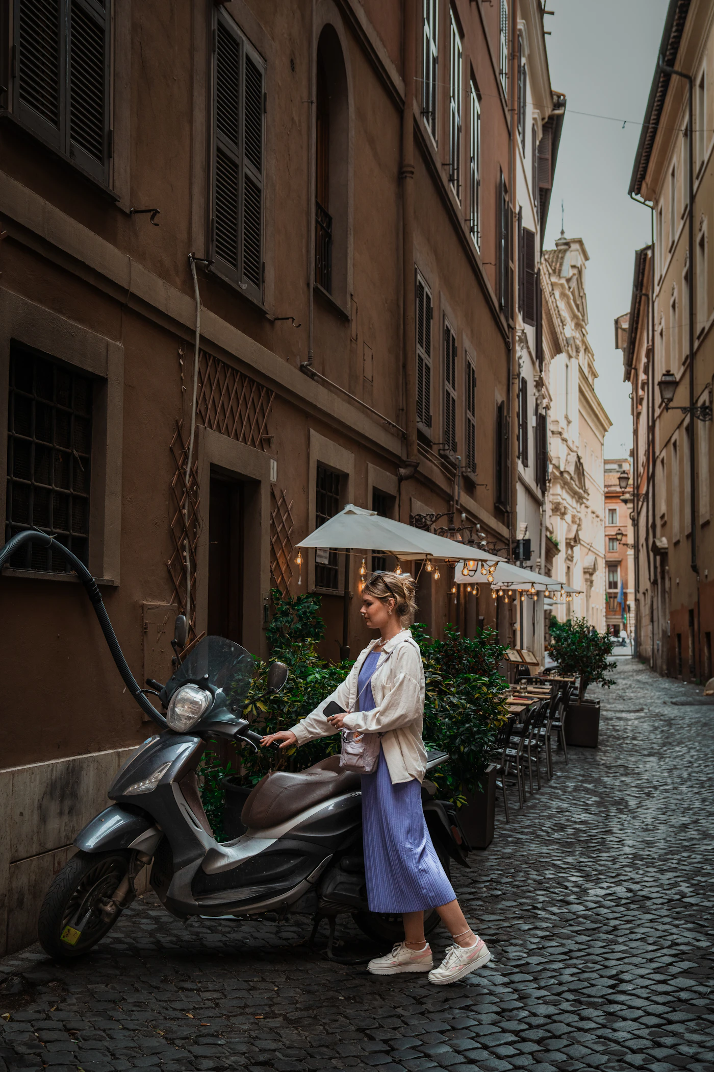 Traveller with a scooter on a cobblestone street