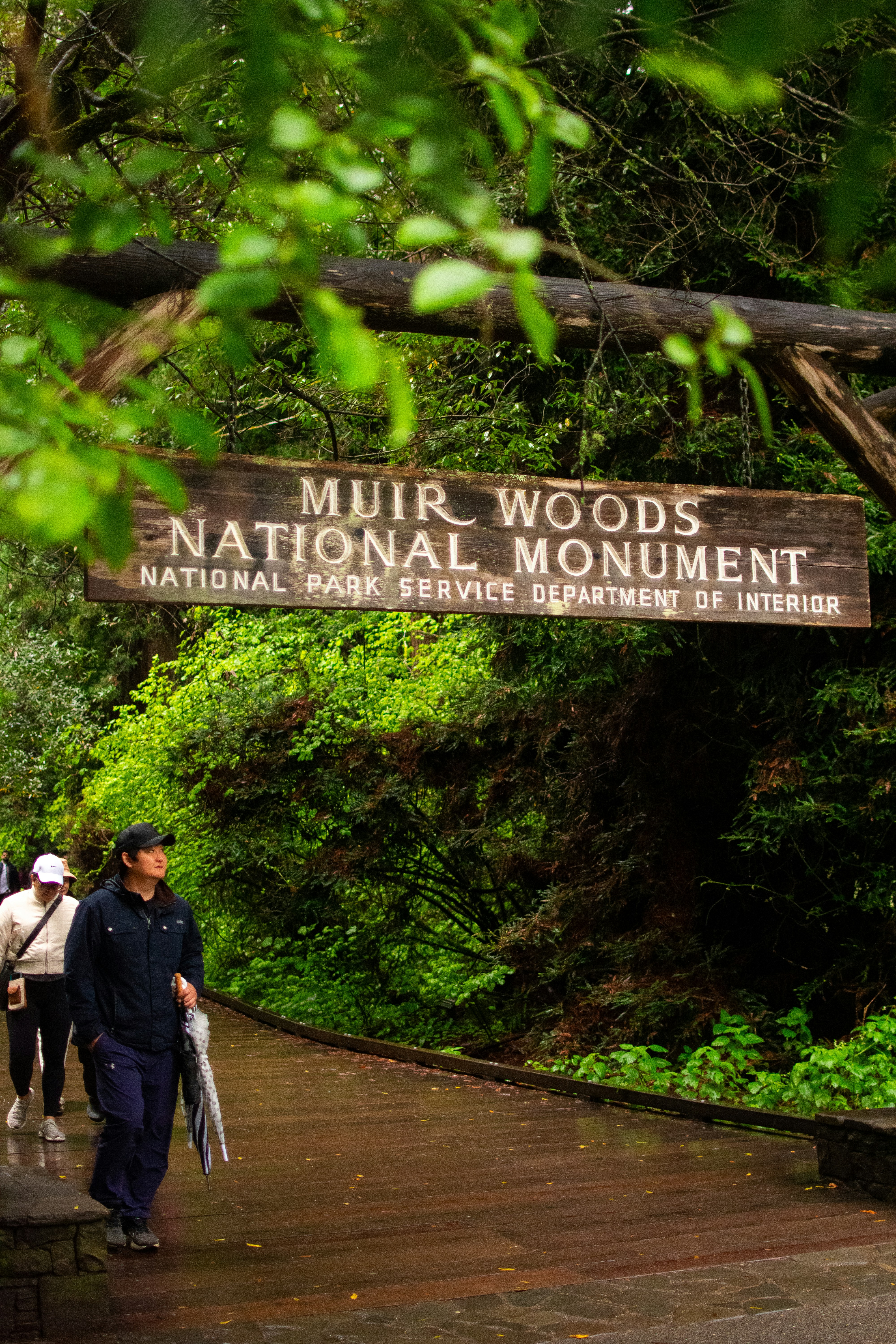A group of people walking across a wooden bridge