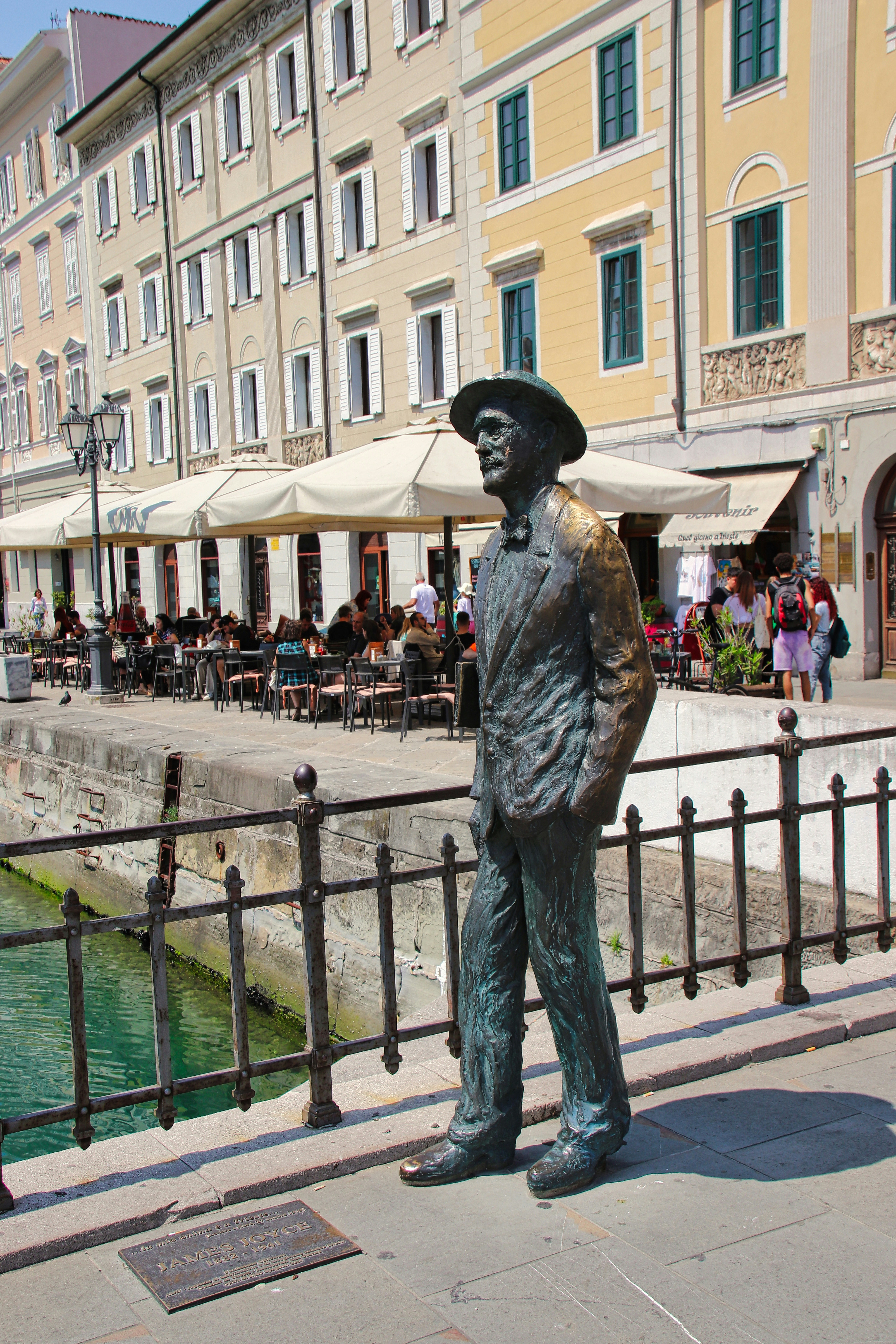 A statue of a man standing next to a river