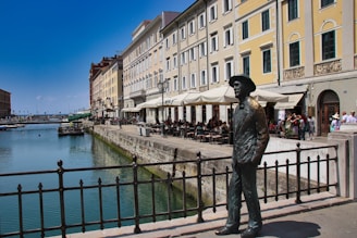 A statue of a man standing next to a body of water