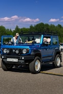 A blue jeep is parked in a parking lot