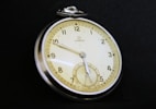 A close up of a pocket watch on a black background