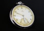A close up of a pocket watch on a black background