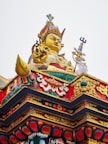 A large golden buddha statue on top of a building