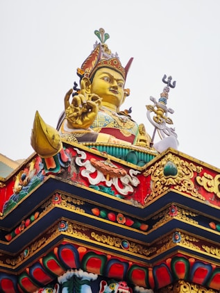 A large golden buddha statue on top of a building
