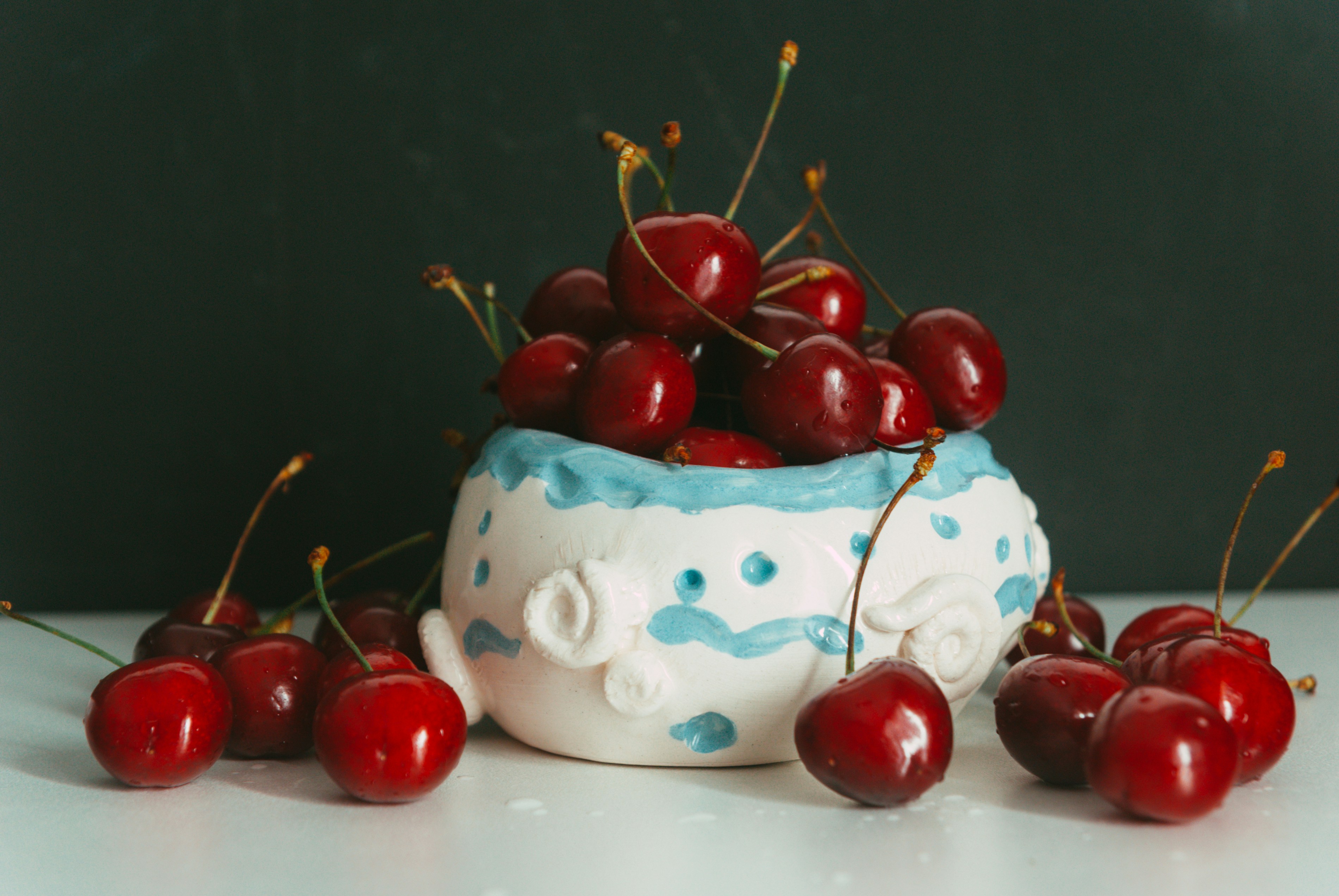 A bowl filled with cherries on top of a table