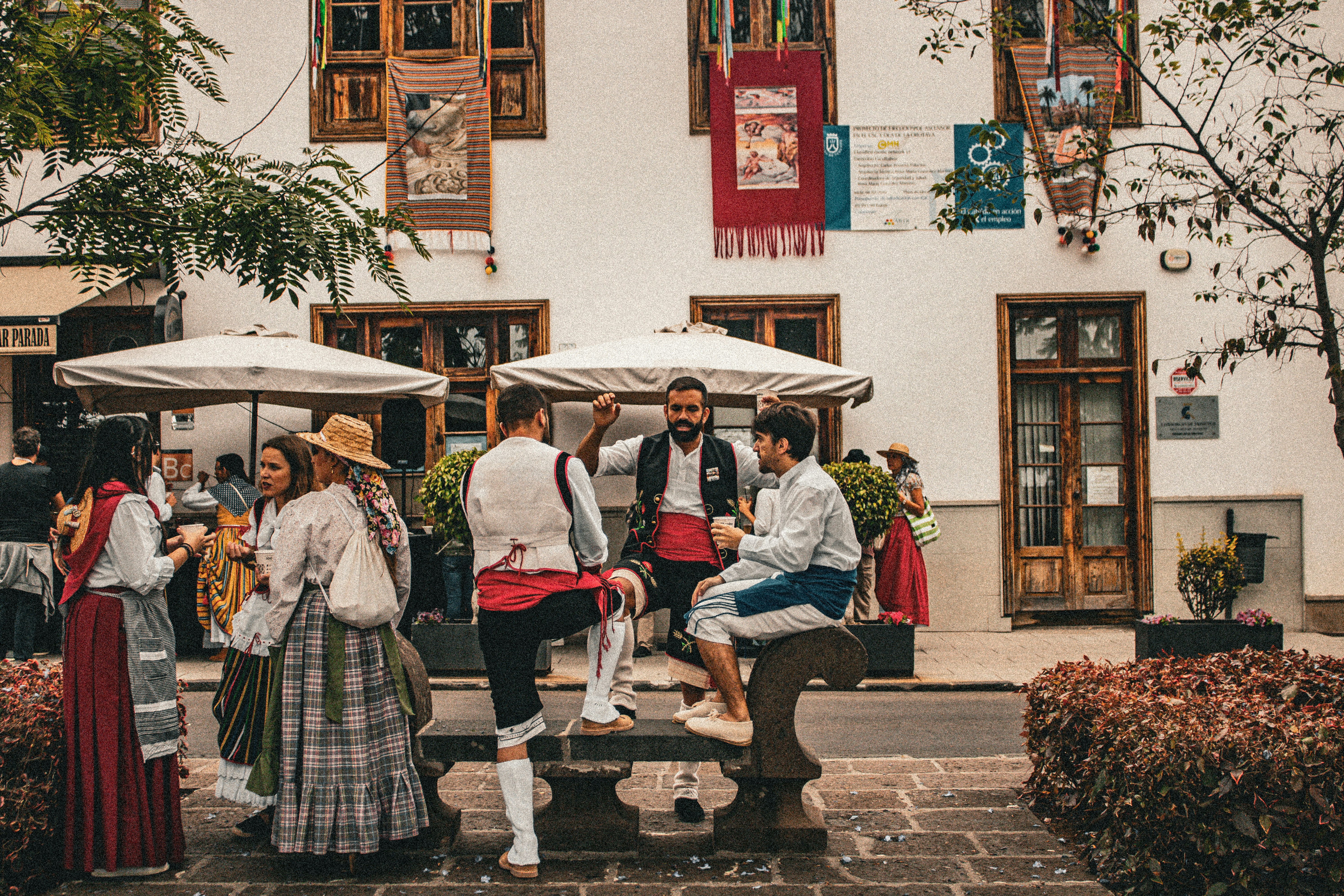 A group of people sitting on a bench in front of a building
