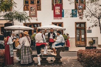A group of people sitting on a bench in front of a building