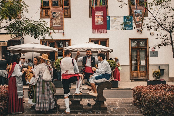 A group of people sitting on a bench in front of a building
