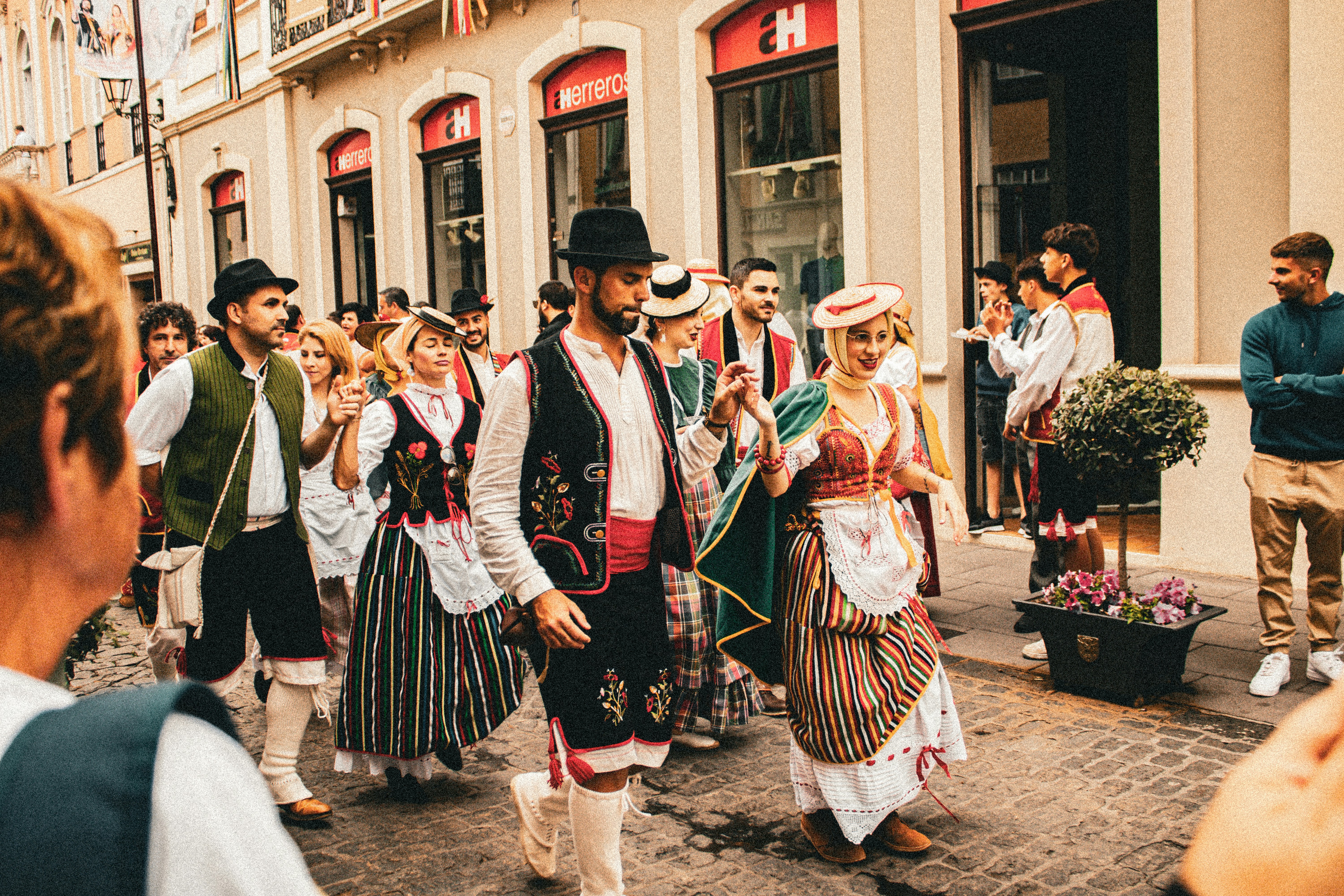 A group of people walking down a street next to each other