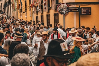 A crowd of people walking down a street next to tall buildings