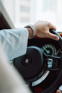 A man driving a car with his hands on the steering wheel