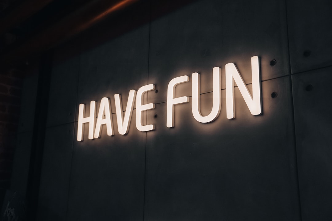 A neon sign that says have fun on the side of a building,