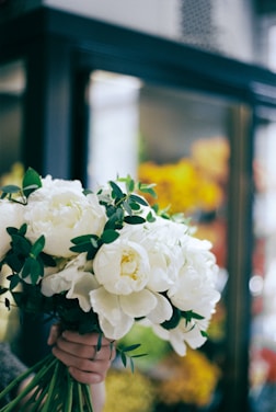 A woman holding a bouquet of white flowers