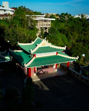 A green and white building surrounded by trees