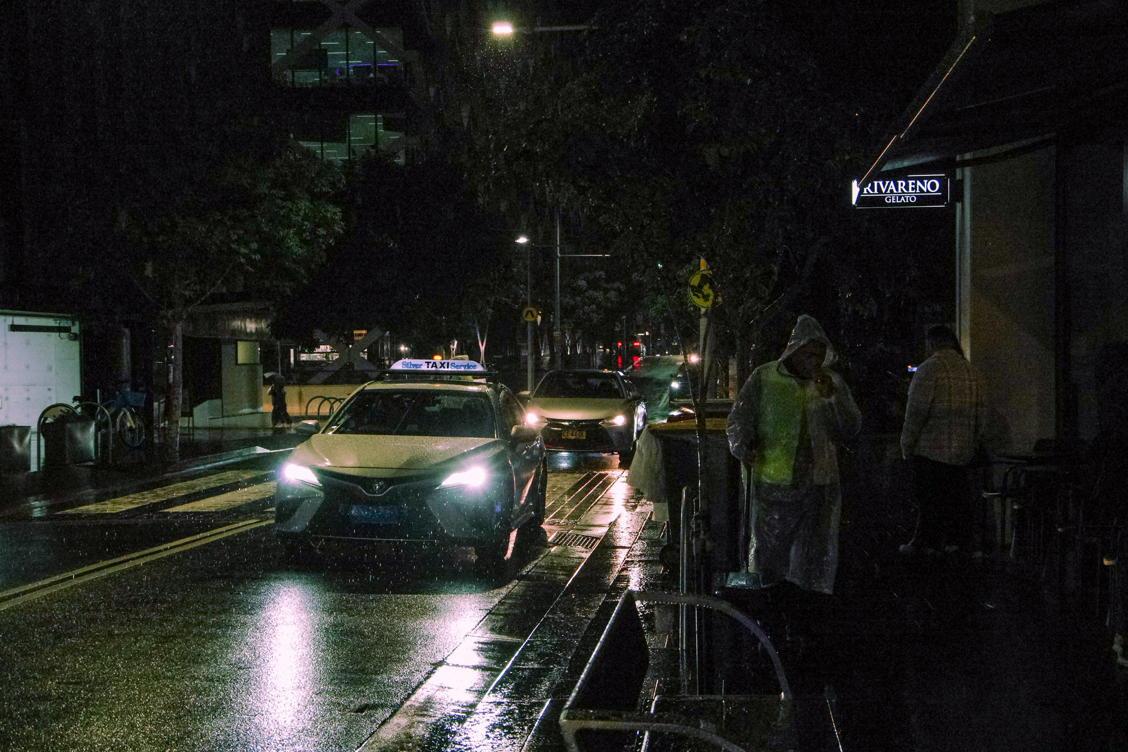 A car driving down a street at night
