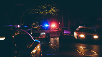 Voitures de police gyrophares allumés dans la nuit, youtubeurs true crime français