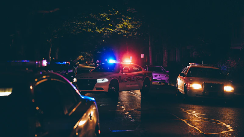 Police cars with flashing lights on a dark street