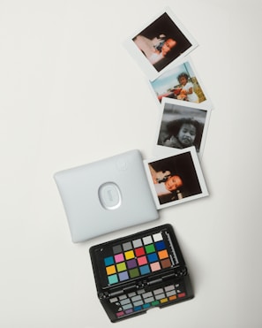 A white table topped with pictures and a remote control
