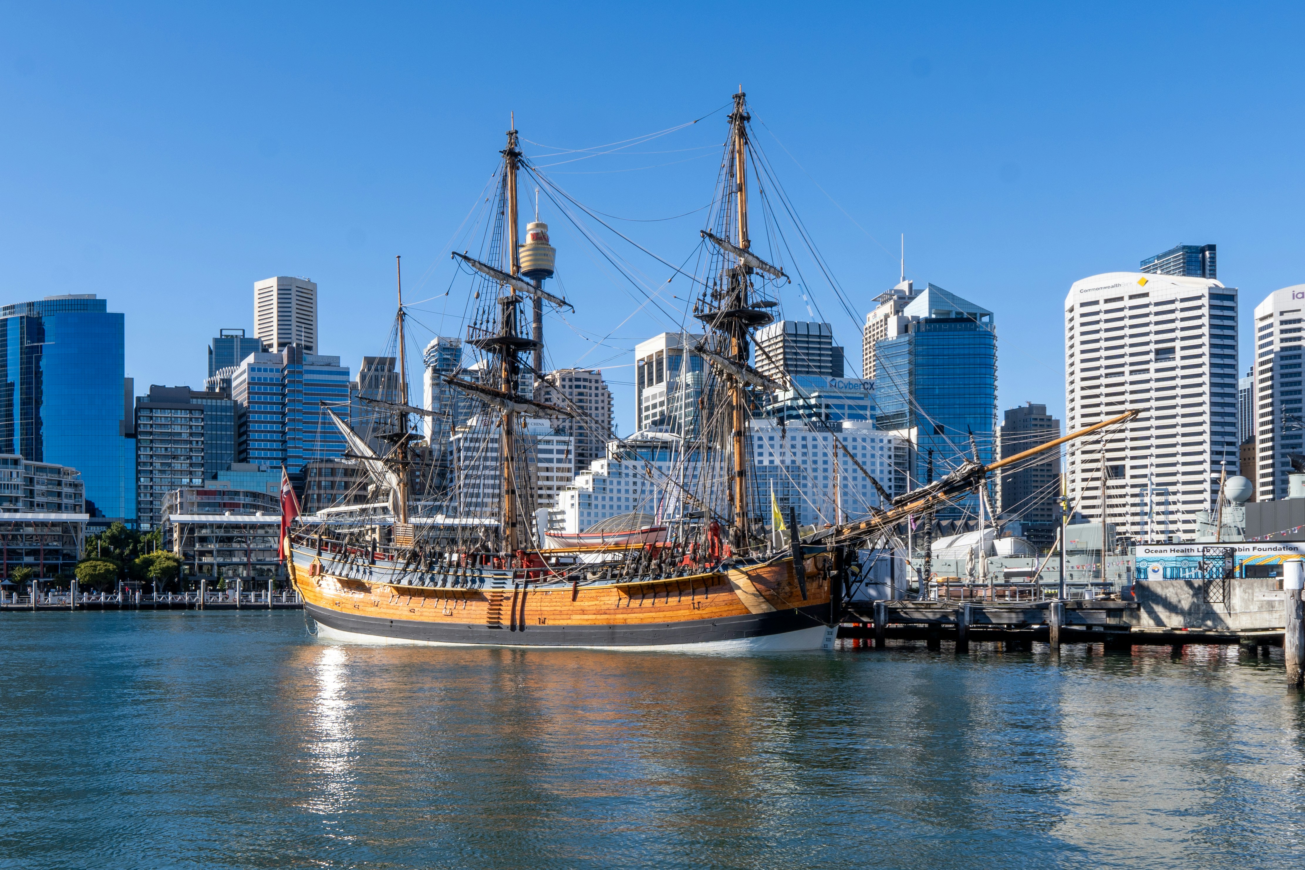 A tall ship in the water near a city