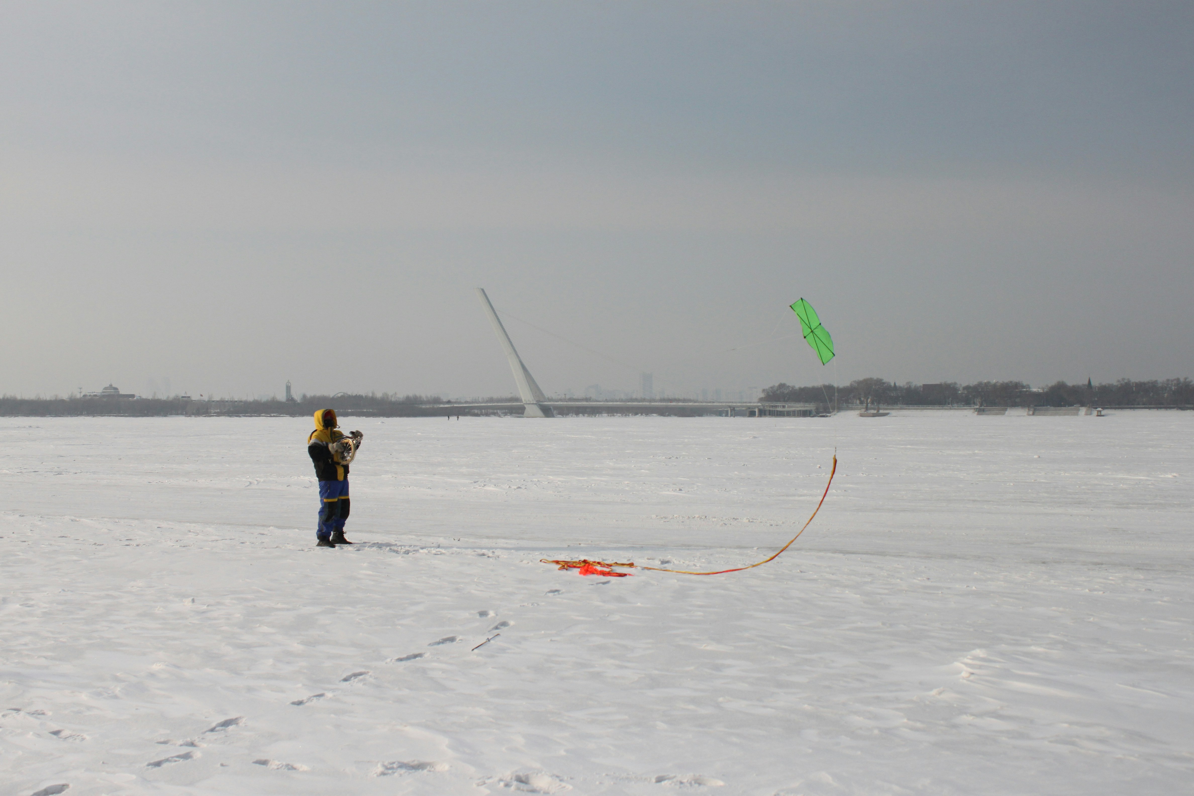 A person flying a kite in the snow