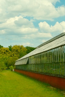 A green house sitting on top of a lush green field