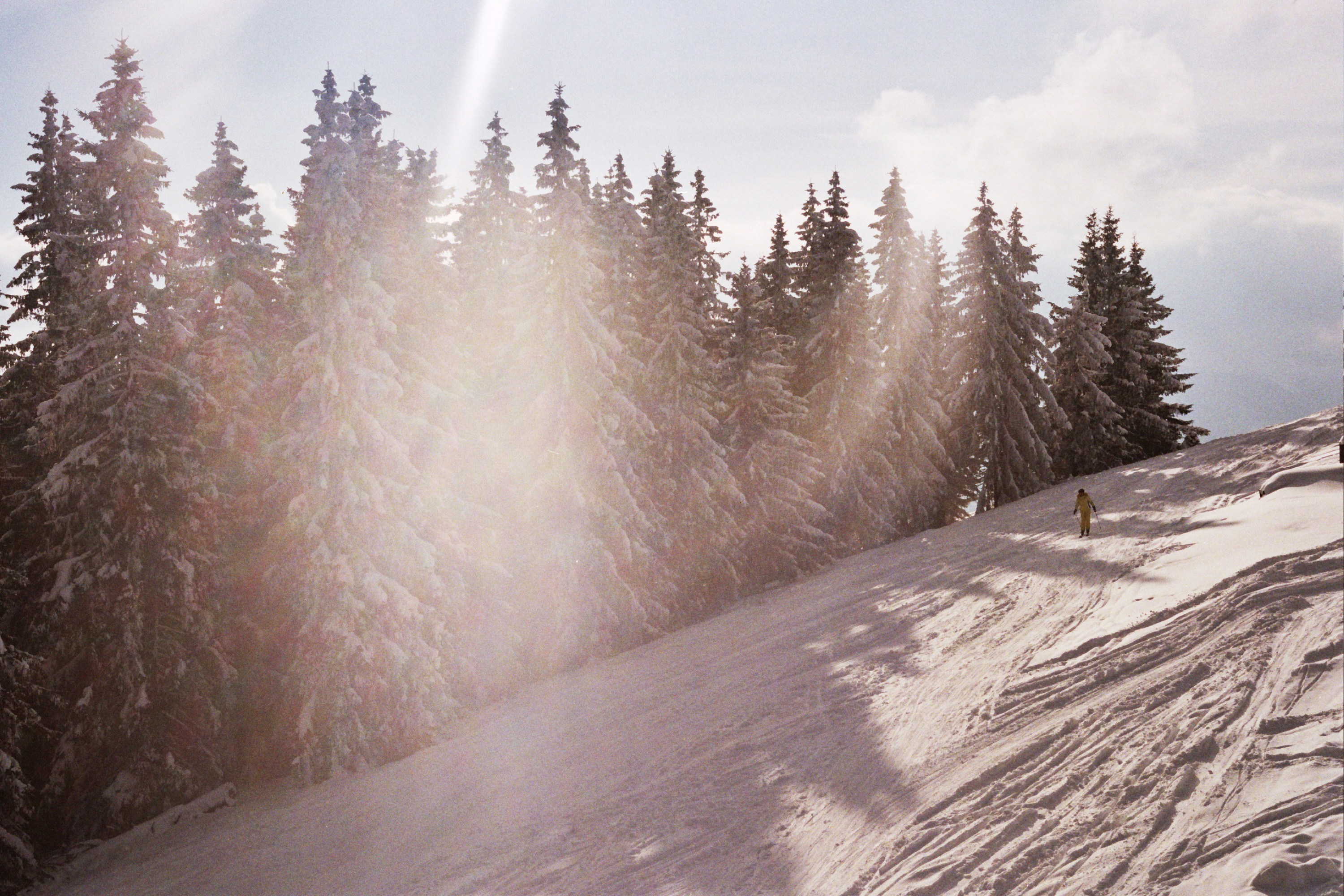 A person riding a snowboard down a snow covered slope