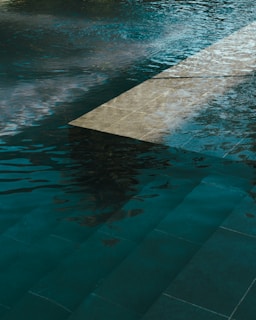 A pool of water with a clock on the side of it