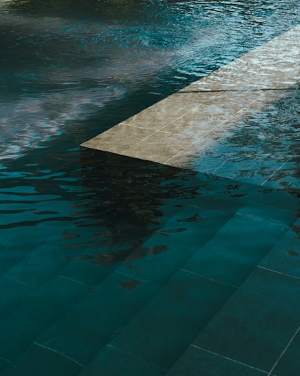 A pool of water with a clock on the side of it