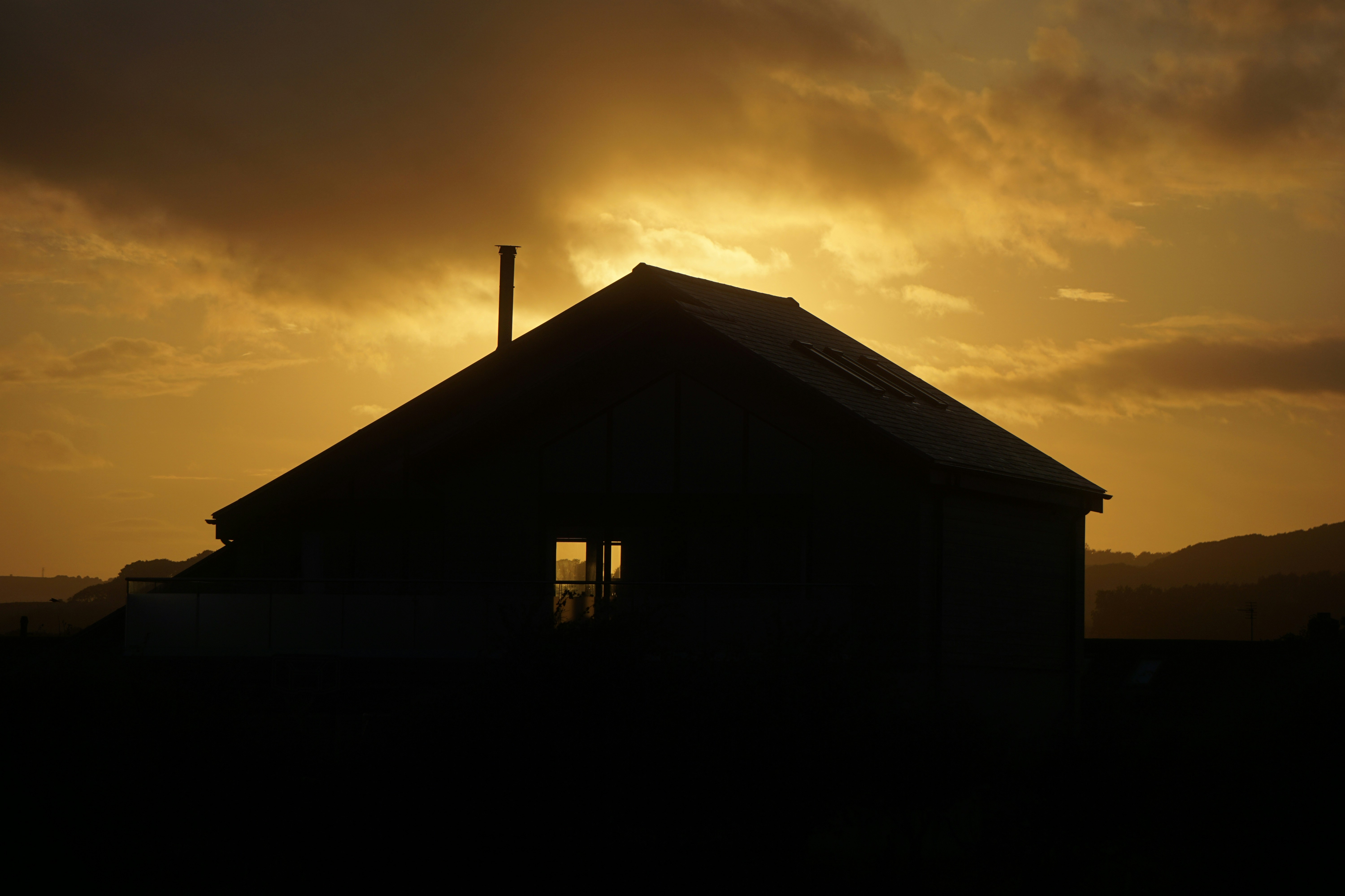 小さな建物の向こうに夕日が沈む