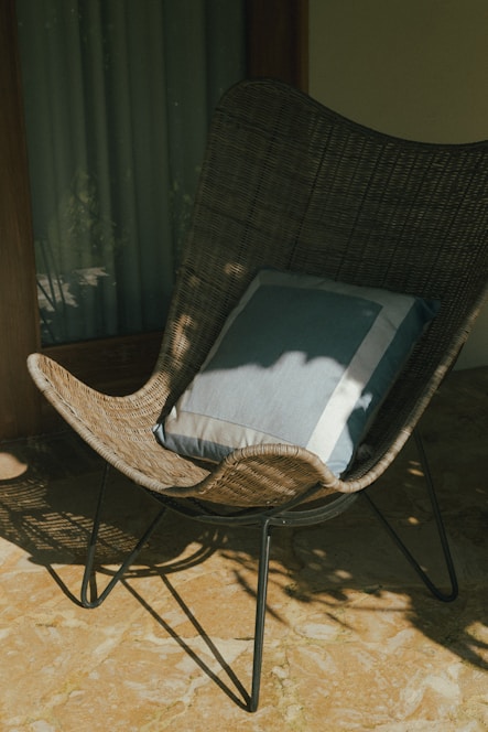 A wicker chair with a pillow on top of it