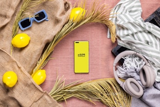 A table with a cell phone, headphones, a scarf, and some other