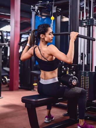 A woman doing squats on a bench in a gym