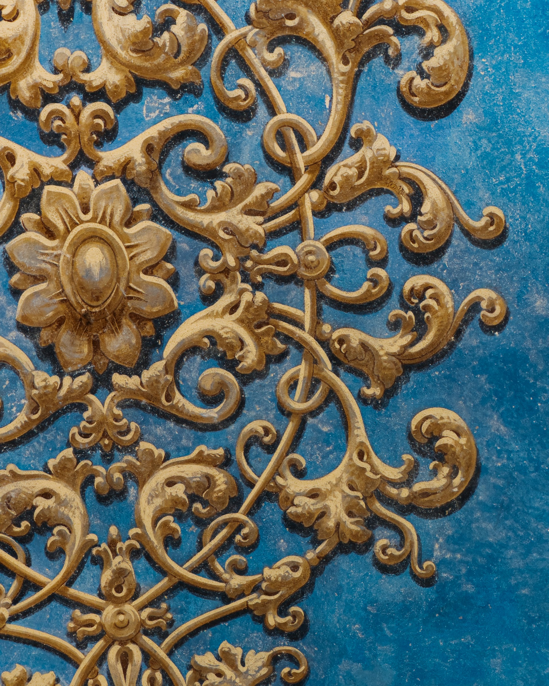 A close up of a gold and blue design on a wall