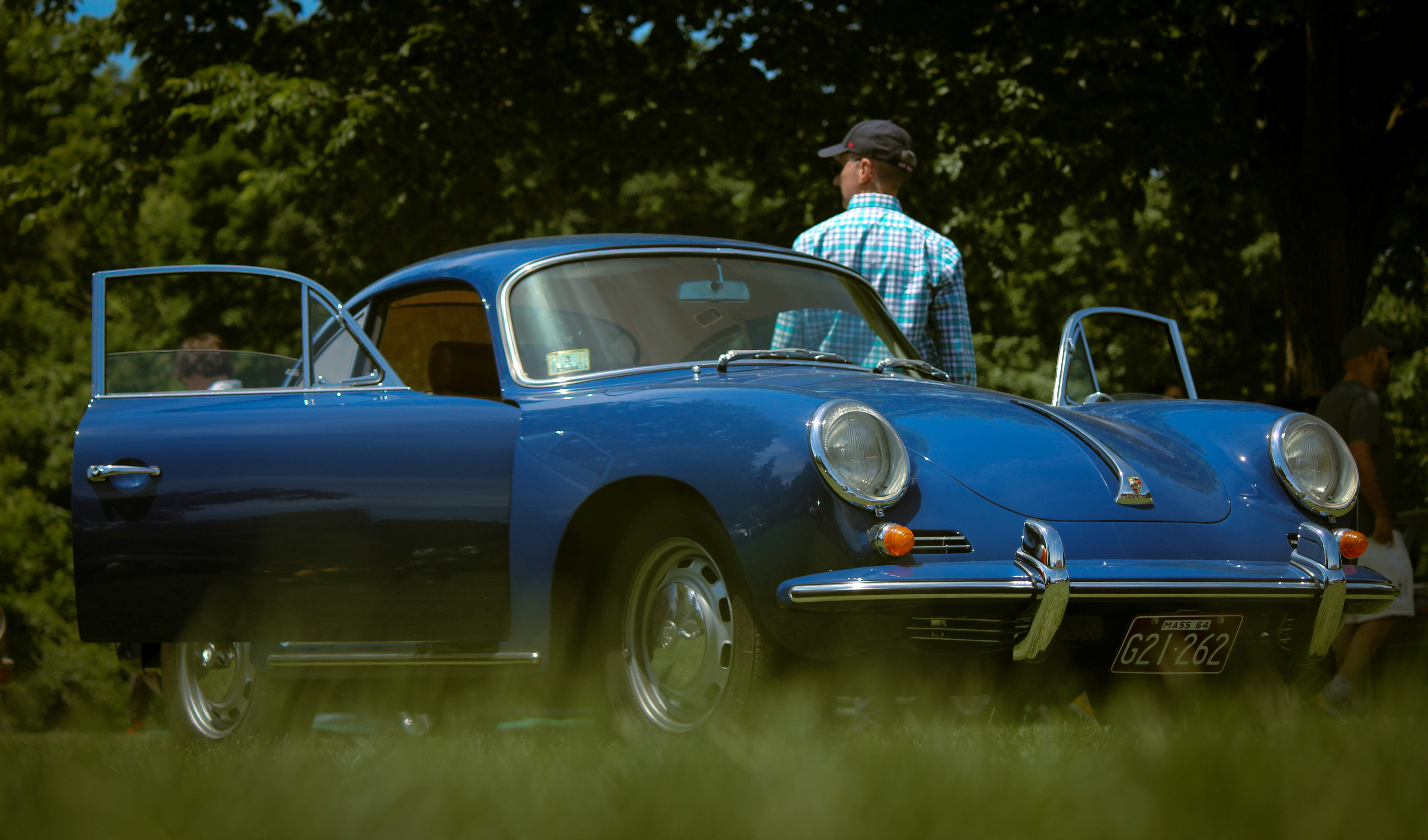 Ein Mann steht neben einem blauen Sportwagen