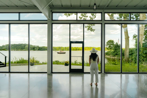 A person standing in a room with large windows