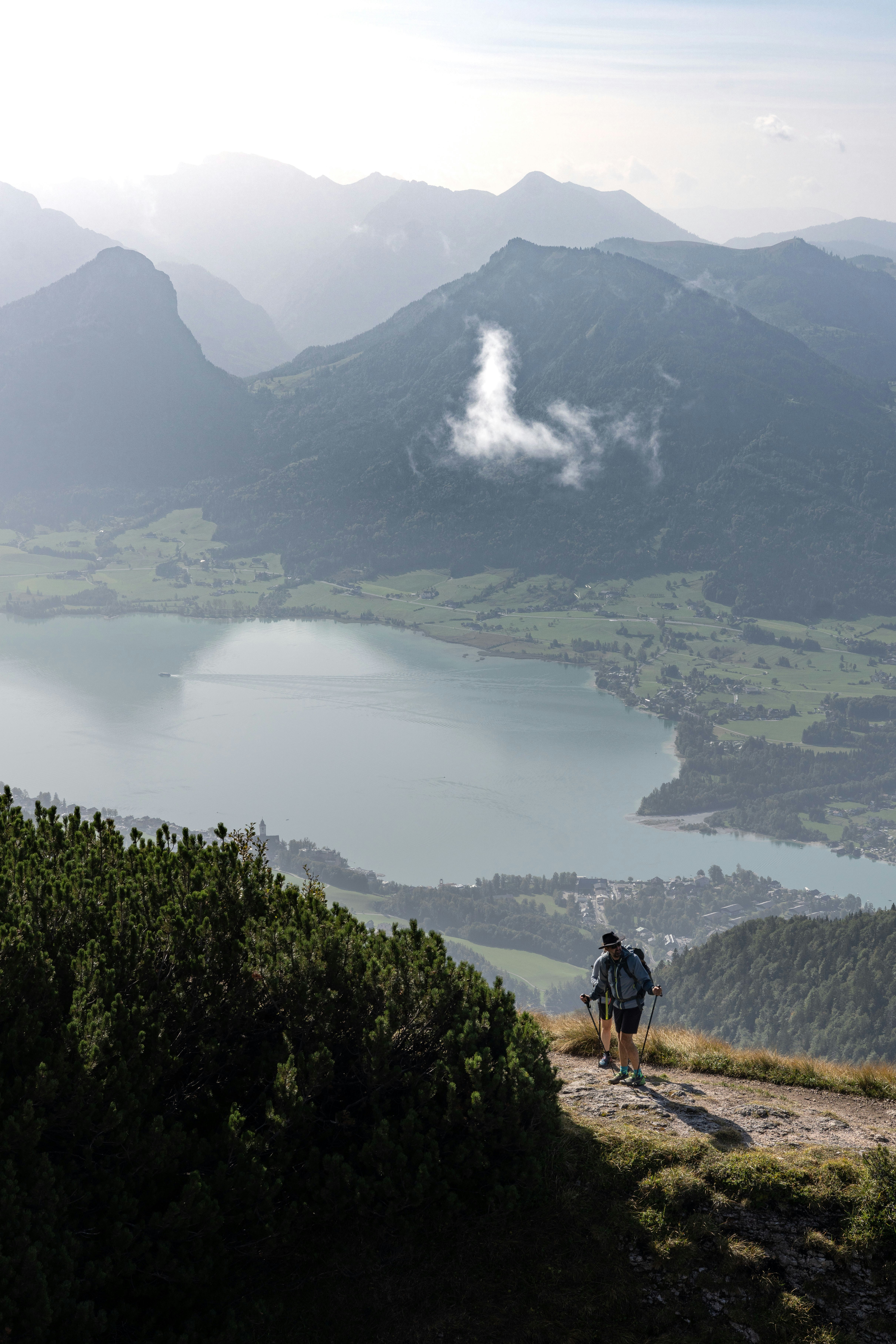 A man hiking up a mountain with a view of a lake