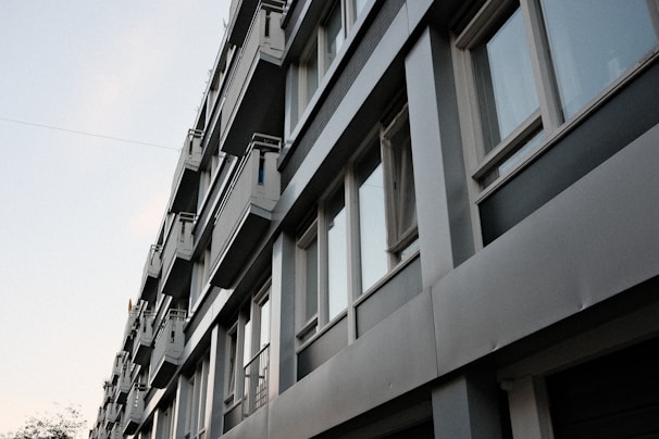 A tall building with lots of windows next to a street