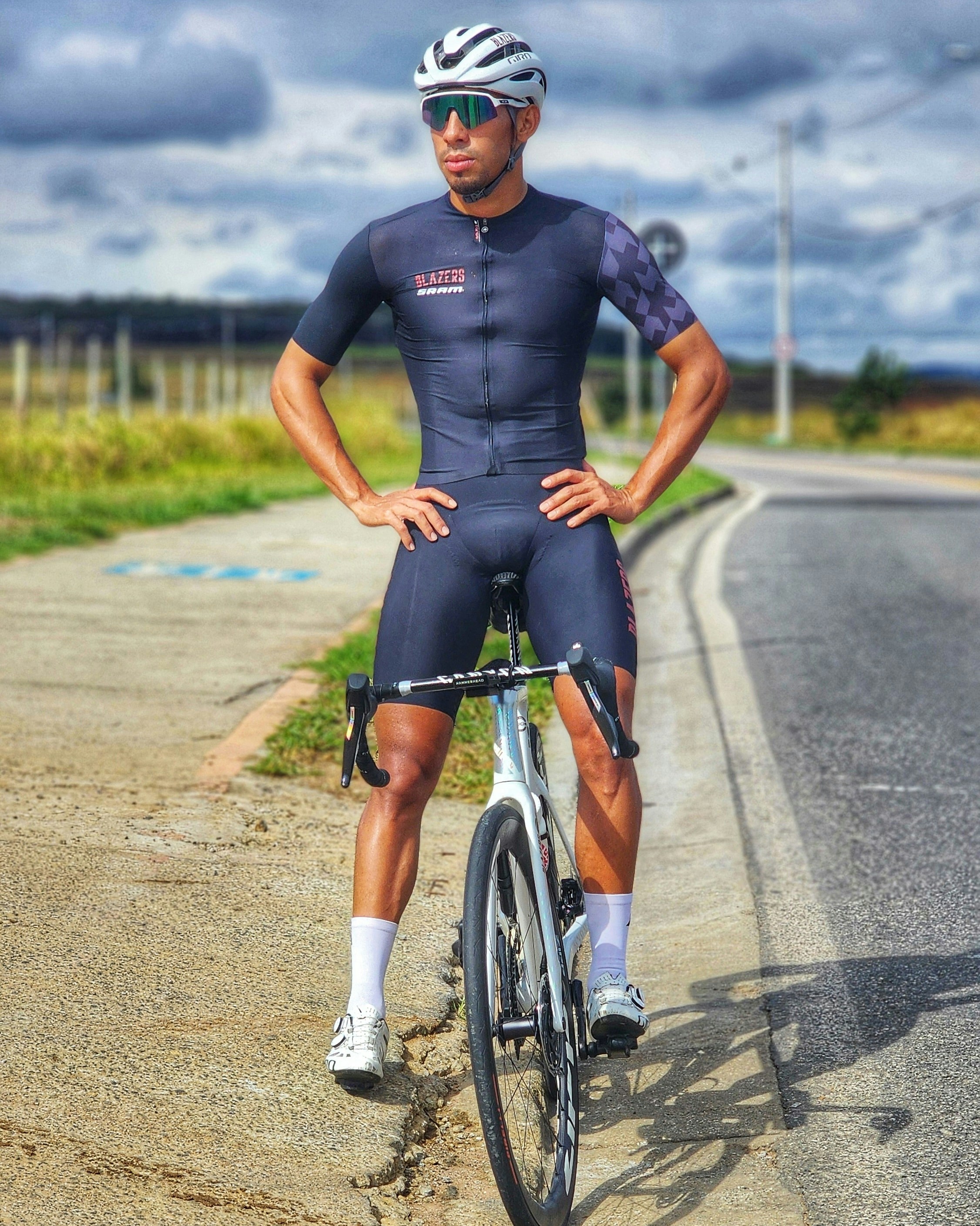 A man is standing on a bike on the side of the road