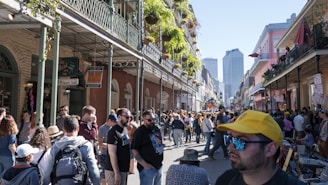 A crowd of people walking down a street next to tall buildings