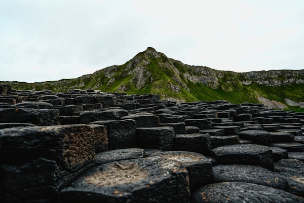 A large group of rocks with a mountain in the background