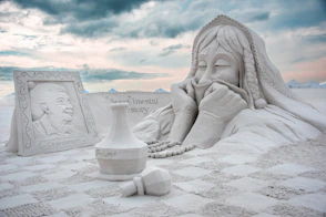 A sculpture of a woman sitting on top of a blanket