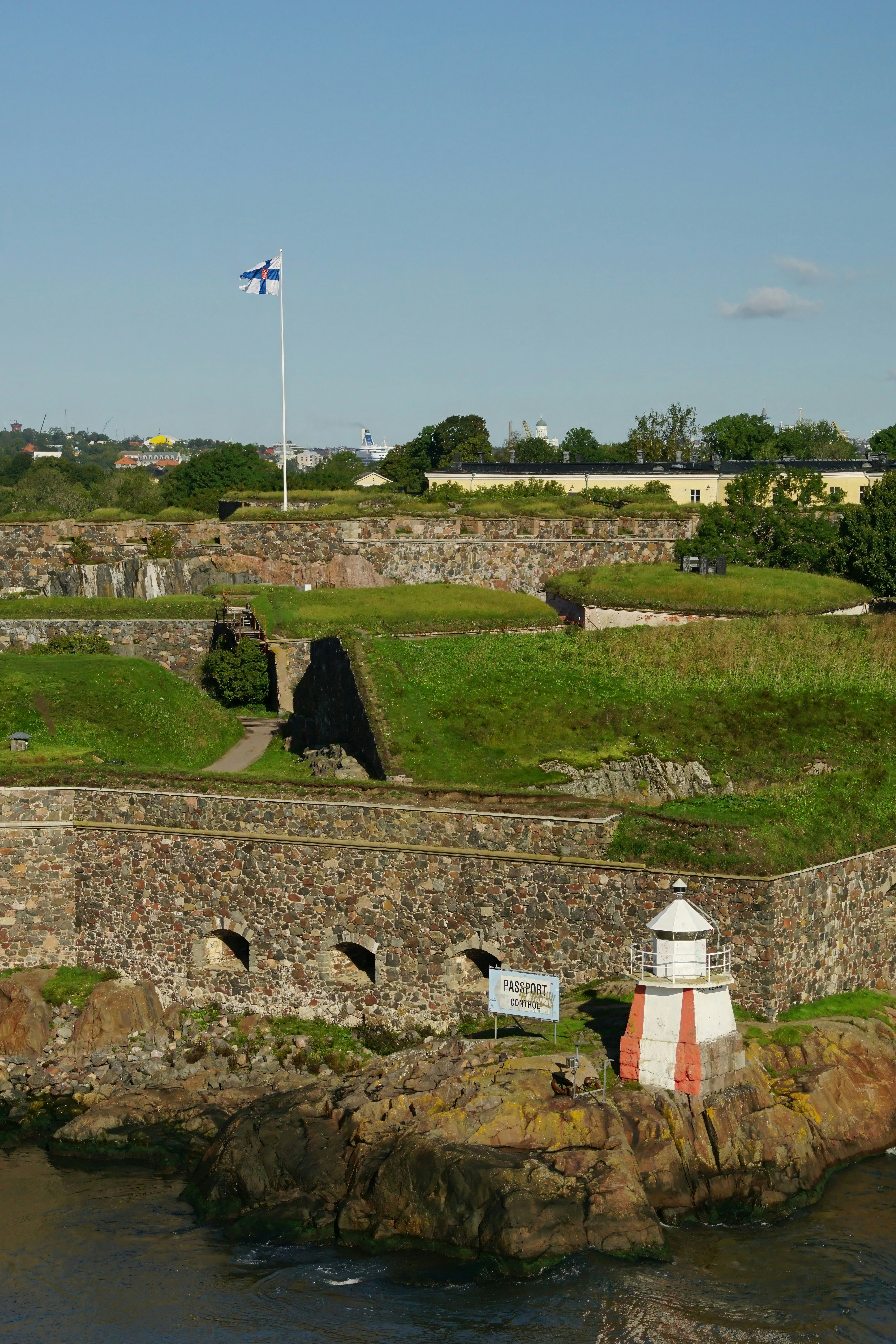 A lighthouse on a rock outcropping next to a body of water