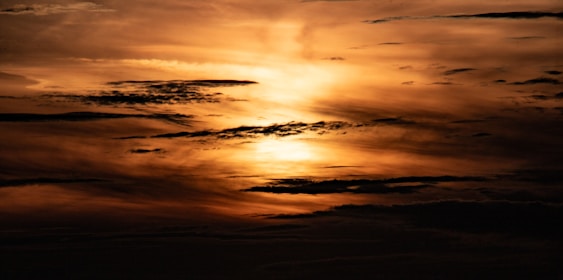 The sun is shining through the clouds in the sky