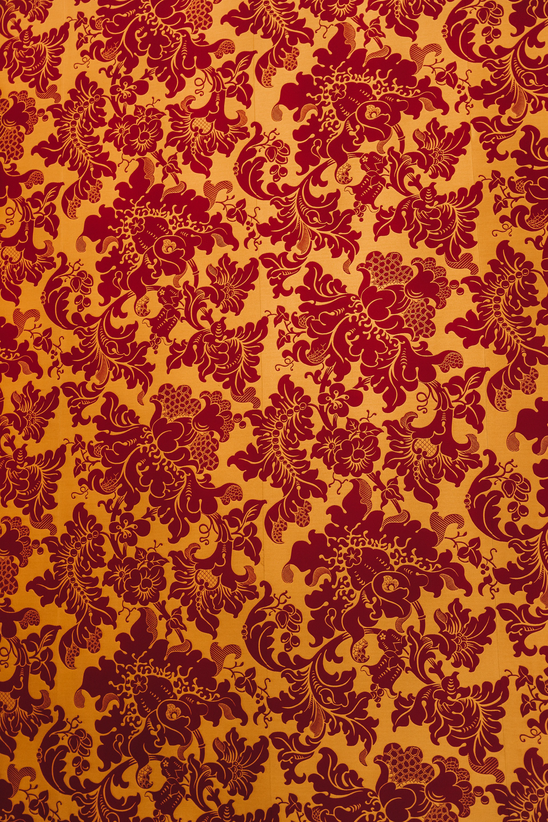 A red and yellow wallpaper with a floral pattern