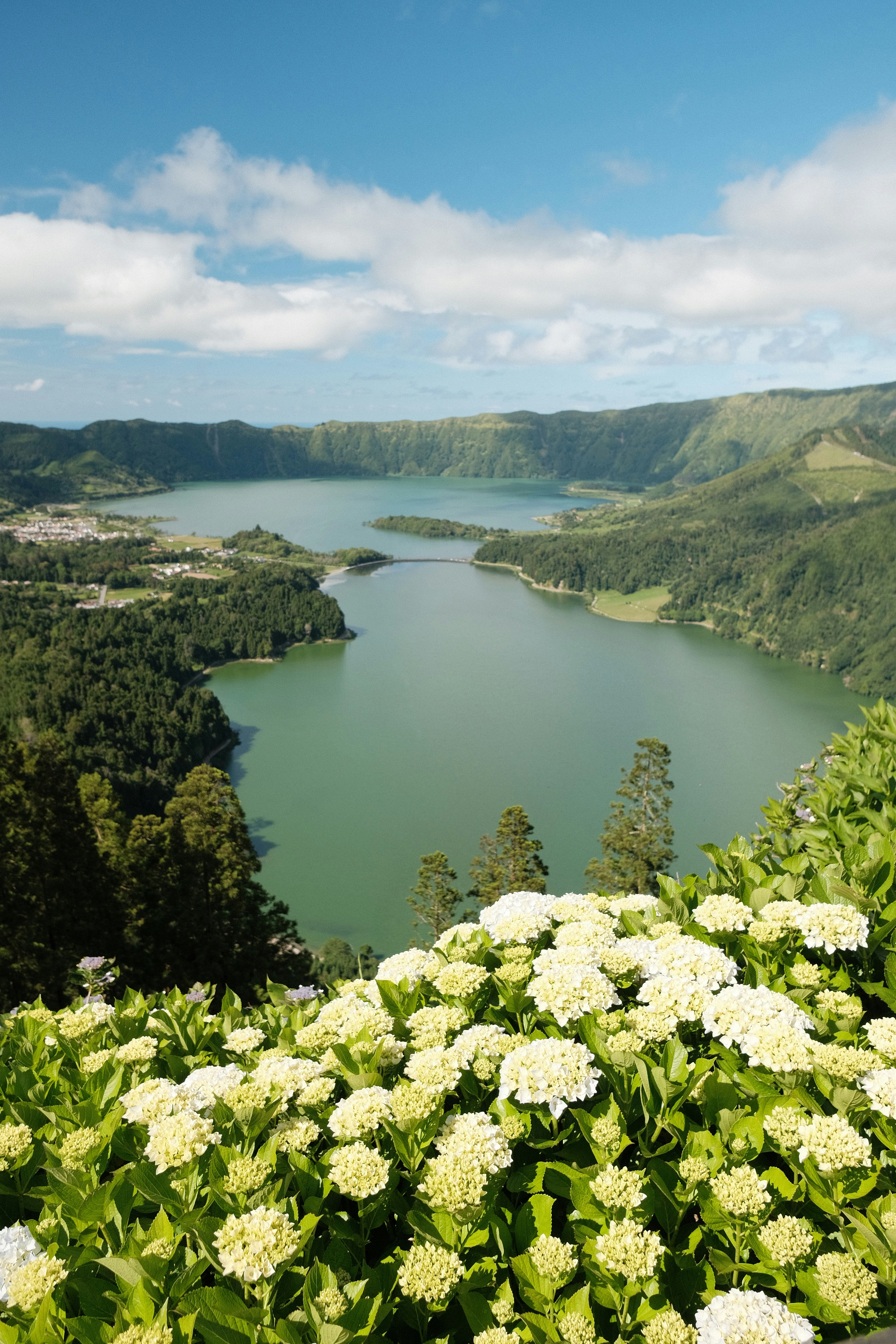 A large body of water surrounded by lush green hills
