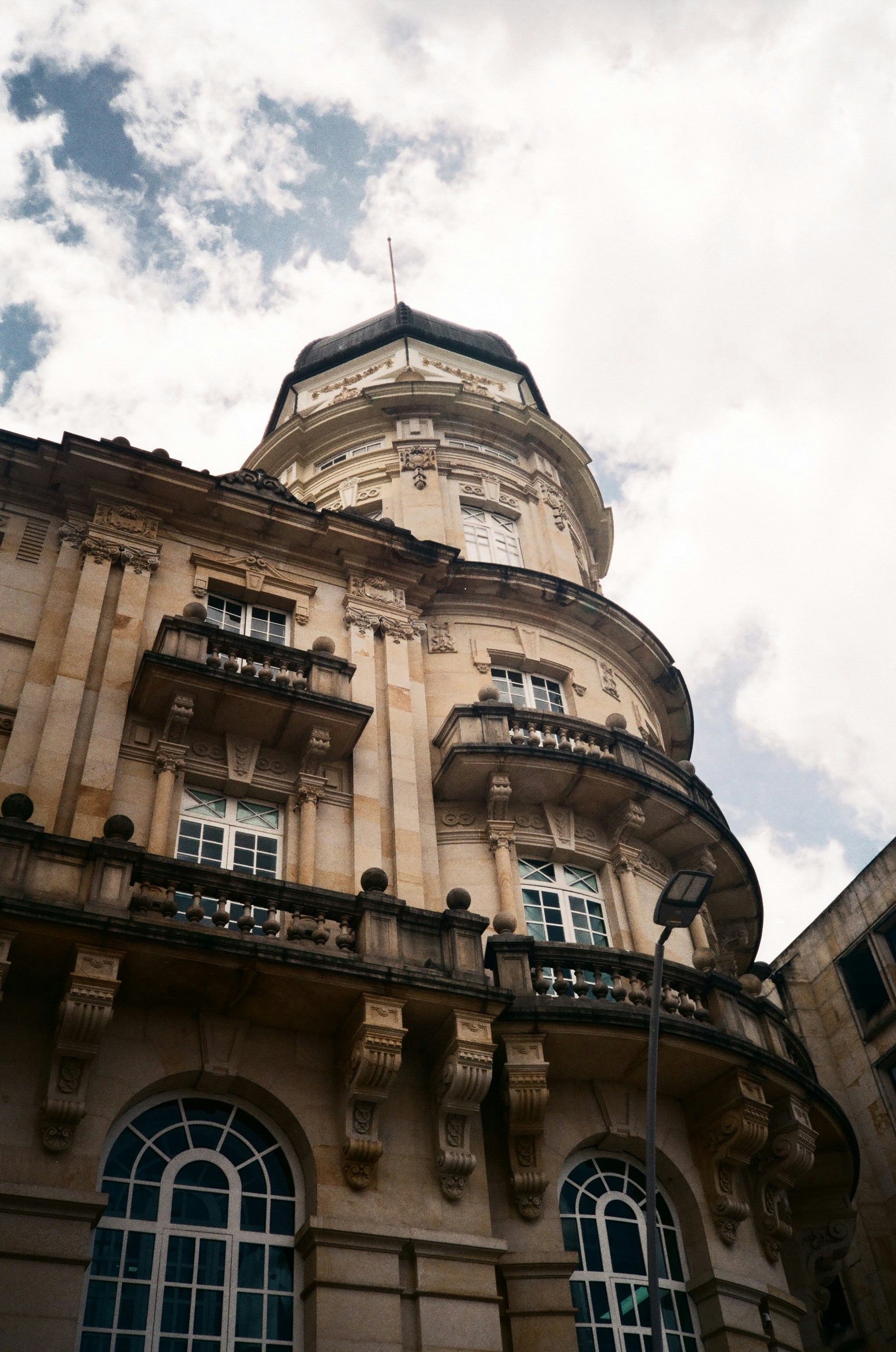 A tall building with lots of windows under a cloudy sky