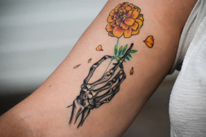 A person with a tattoo on their arm holding a flower