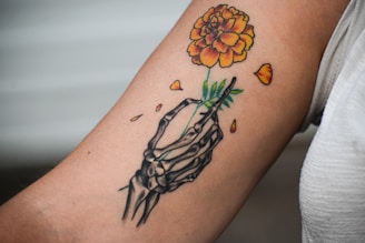 A person with a tattoo on their arm holding a flower